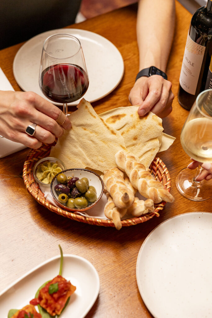 Voorgerecht van brood, boter en olijven en wijnglas op tafel